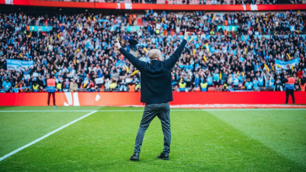 Pep Guardiola celebrating with manchester city fans after booking a place in the FA Cup Final